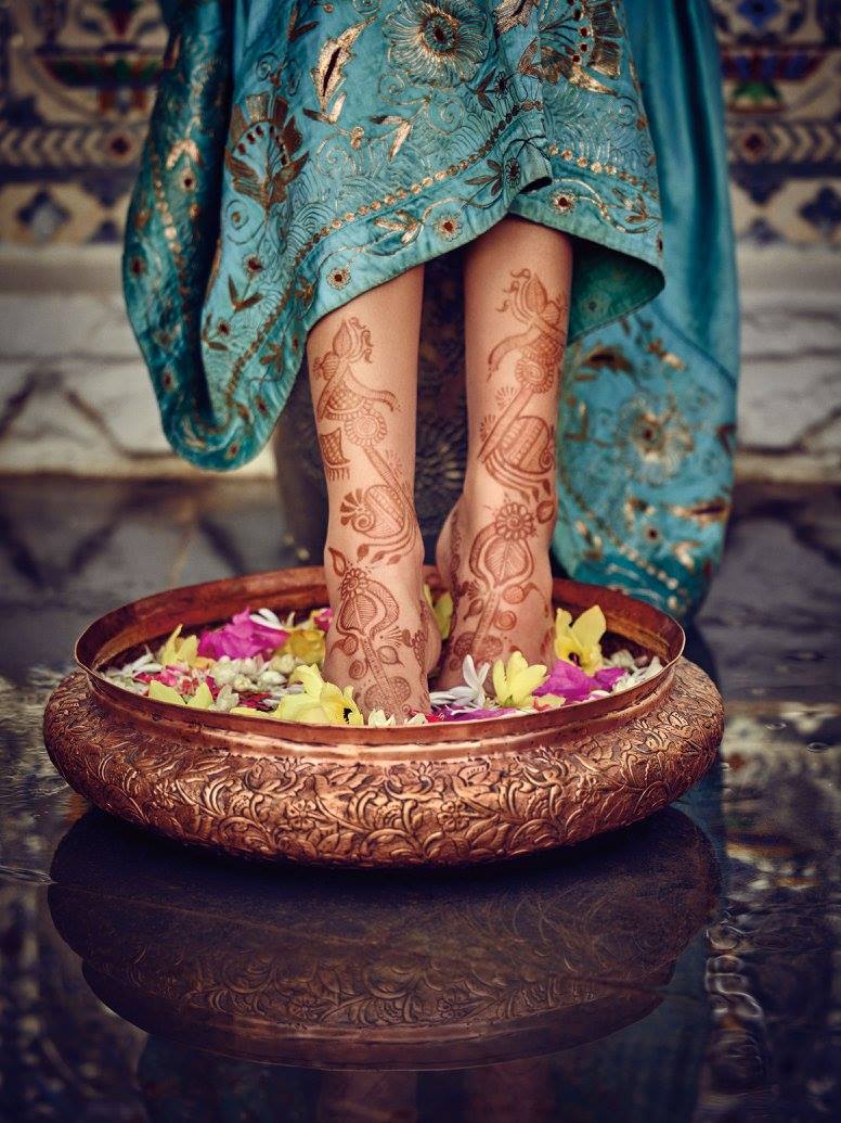 woman soaking her feet in water with flowers in